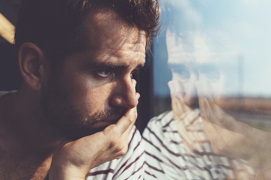 Sad-young-man-looking-through-the-window-606671220_5237x3491